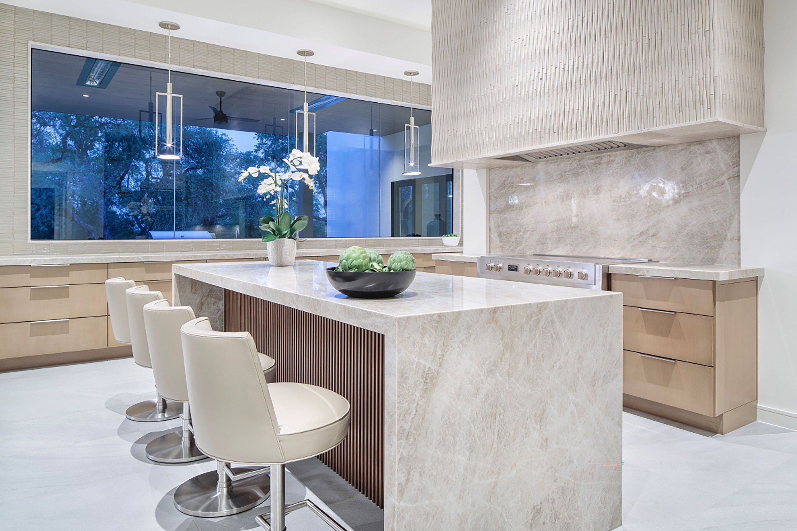 Nature's Retreat — kitchen island with waterfall stone counter and fluted wood base