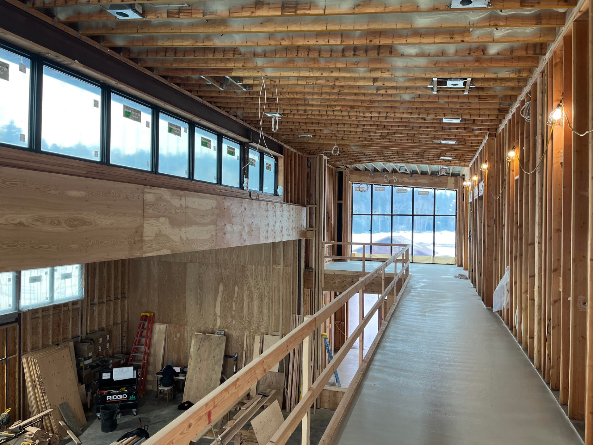 Lazy Creek under construction — framed upper walkway, timber joists, and clerestory windows